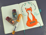 Journal page with a picture of a fox and two bottles of TWSBI ink and a Orange TWSBI Eco fountain pen.